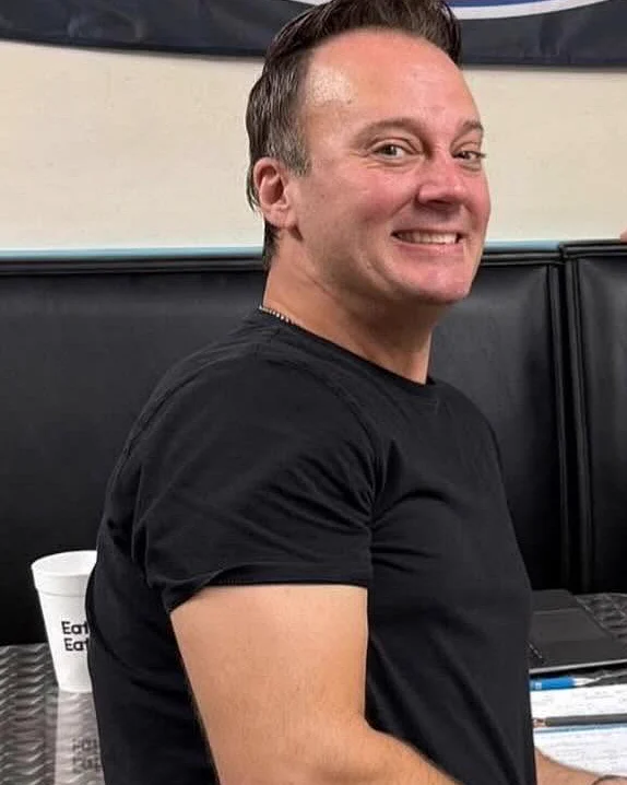 Bobby, who runs the weddings at David's Catering, smiling at a table in the restaurant.