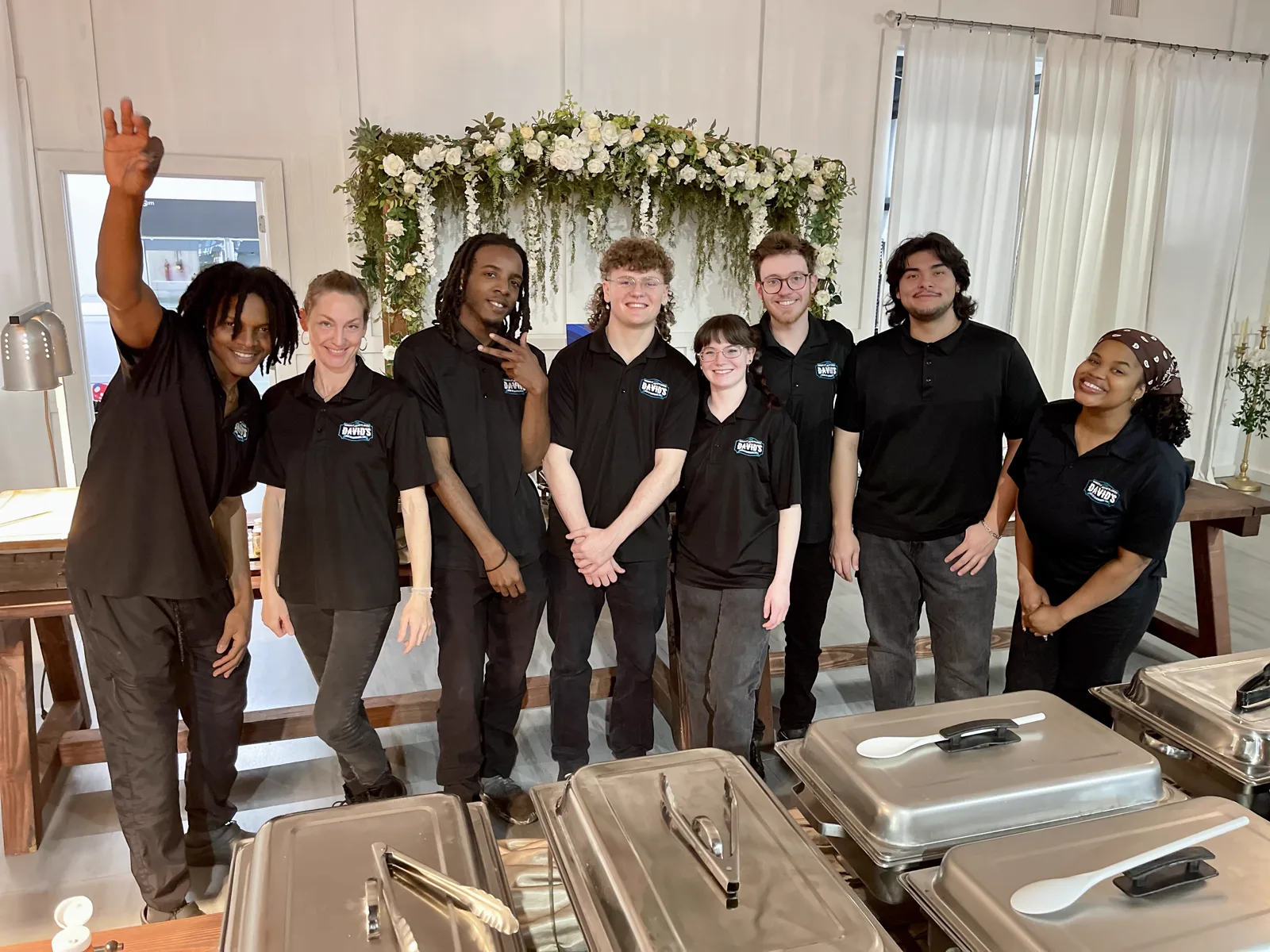 The David's catering team lined up behind a row of chafing dishes before service.